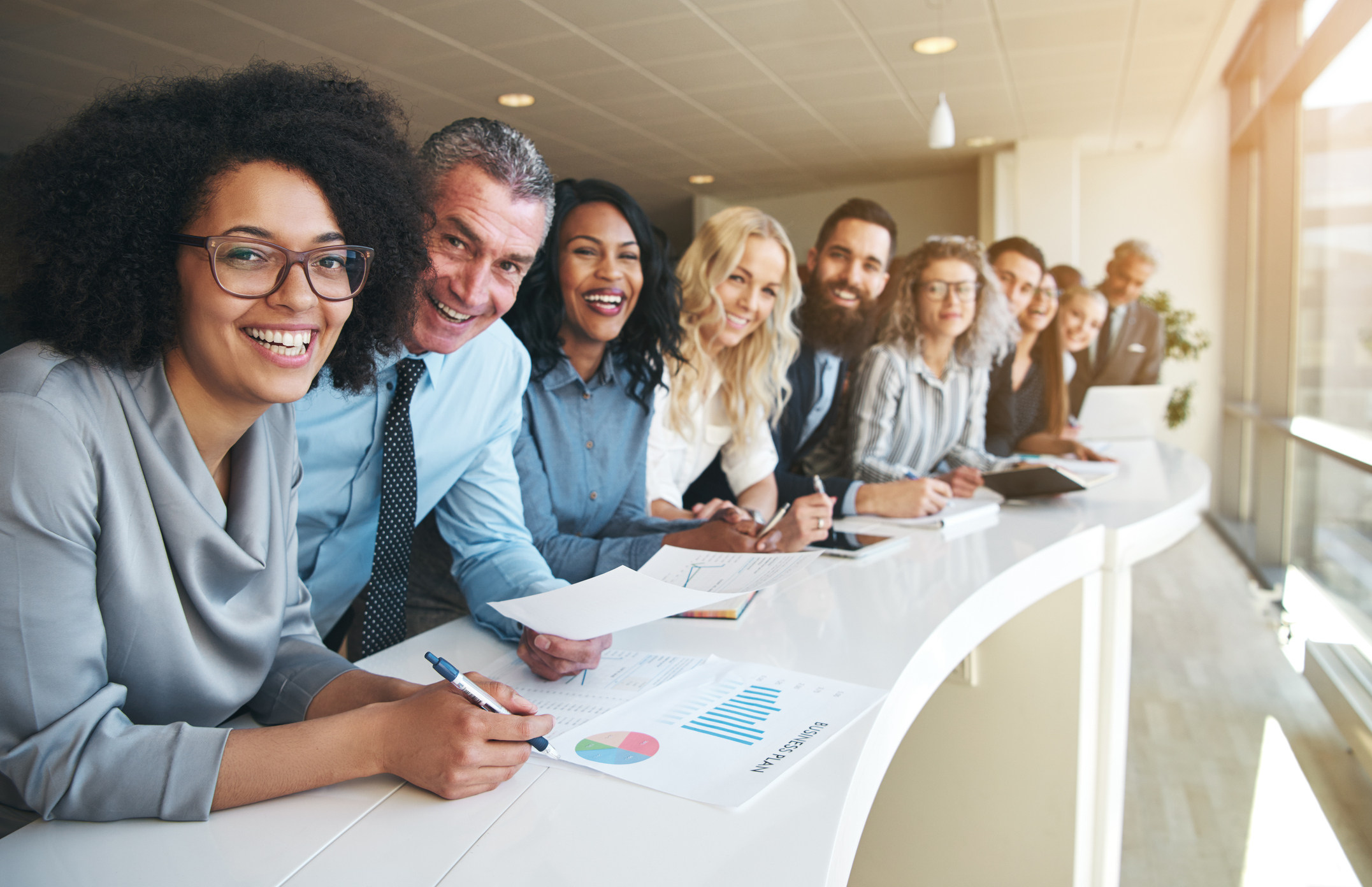 690855708 Cheerful multiracial colleagues looking at camera in office