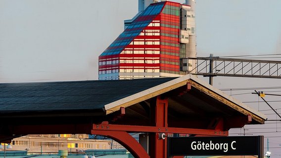 Gothenburg Central Station with the striking red and white Läppstiftet building in the background, capturing urban vibrancy and architectural innovation.