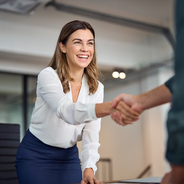 Woman shaking a hand of a business partner.