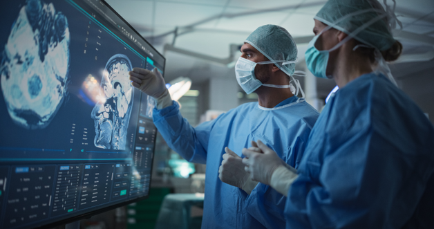 Kirurger analyserar hjärnskanningsbilder som visas på en digital monitor