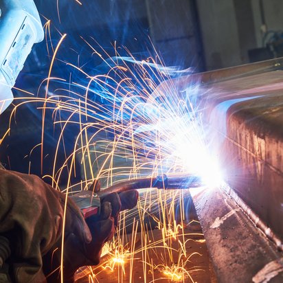A person welds coppar in a dark room. A person welds coppar in a dark room.