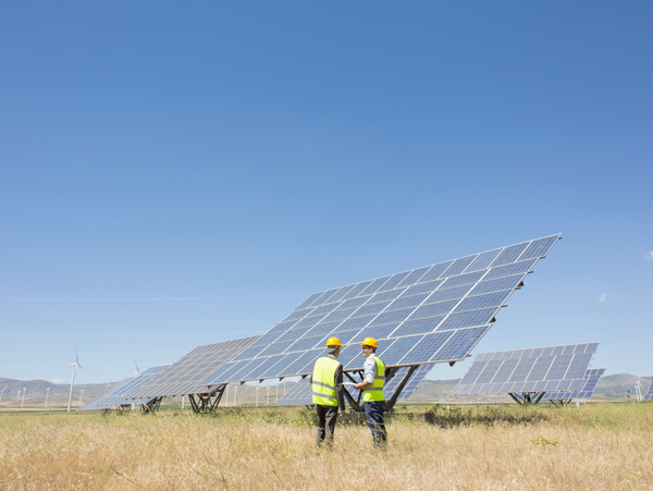 Two engineers are inspecting solar panels