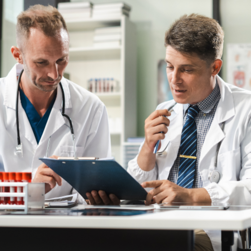 A medical team works together using a tablet and a laptop