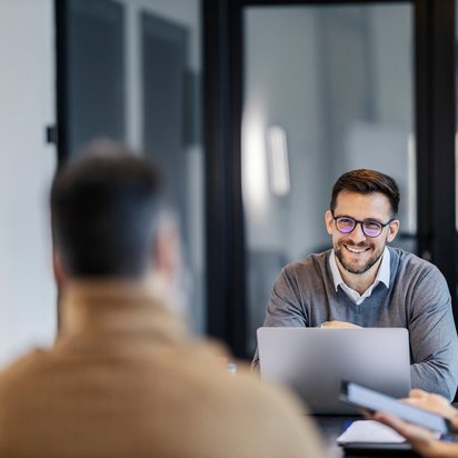 A man discussing in a meeting with coworkers.