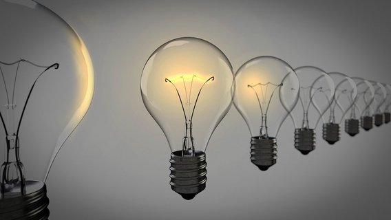  A row of light bulbs, with one illuminated, symbolizing innovation, creativity, and the power of a bright idea.