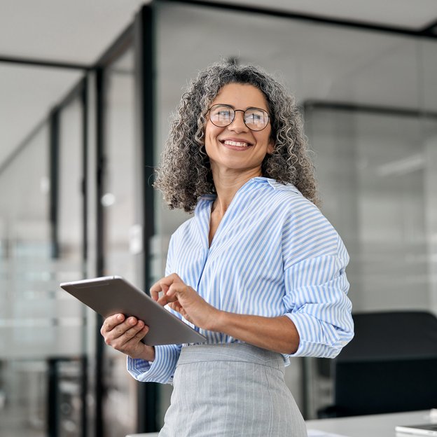 Woman helds a tablet in the office.