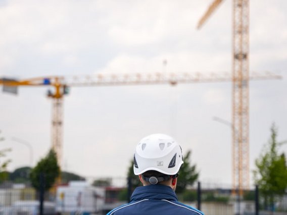 TÜV Prüfer schaut auf Baustelle