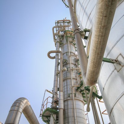 Some pipes are seen from below and are going up to the sky on two chimneys.