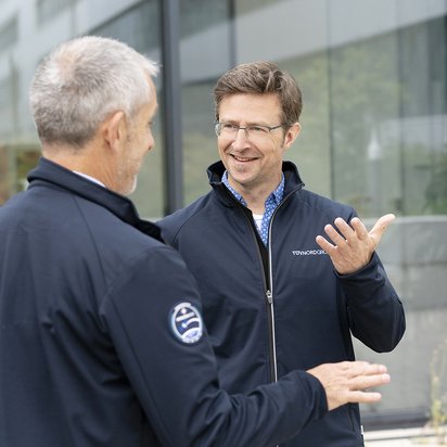 Employees of TÜV NORD are talking to each other.