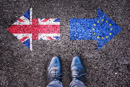 Brexit, flags of the United Kingdom and the European Union on asphalt road with legs