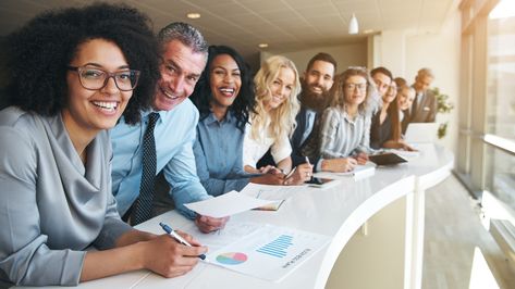 Cheerful multiracial colleagues looking at camera in office