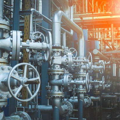 A lot of pipes and valves for the pipes, the sun is shining on the right side of the picture. A lot of pipes and valves for the pipes, the sun is shining on the right side of the picture.