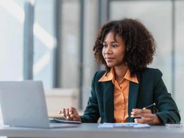 A person attending a conference or a meeting on her laptop. 